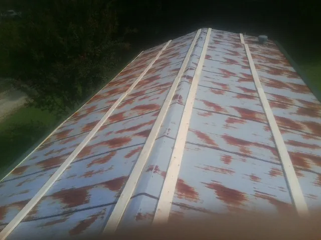 Rusted metal roof panels with new wood purlins before replacement — Storm Damage Roof Repair in Woburn by Roofing Brothers