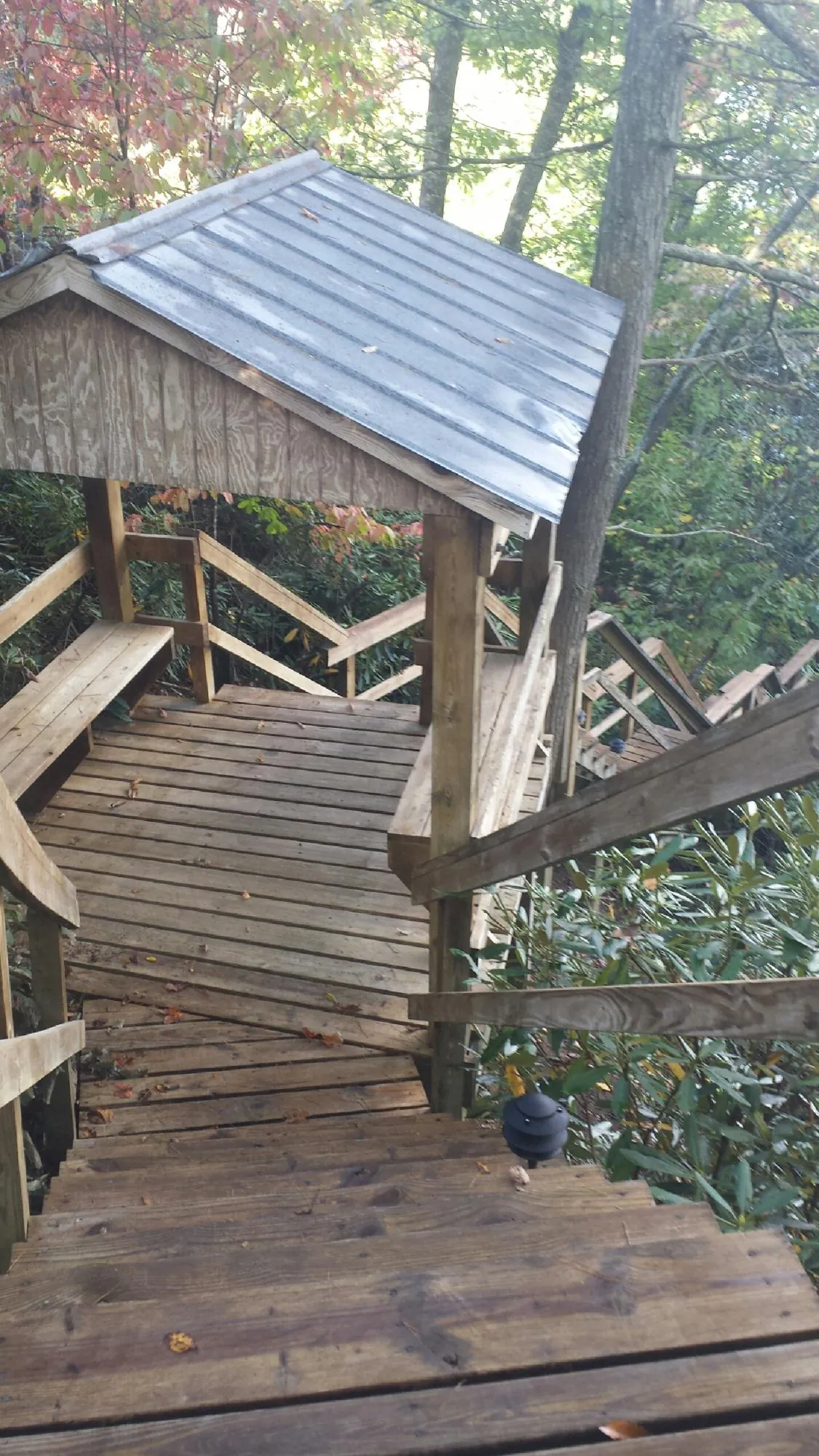 Metal roofed shelter over wooden steps on a wooded walkway — Skylight Repair & Installation work by our crew in Woburn