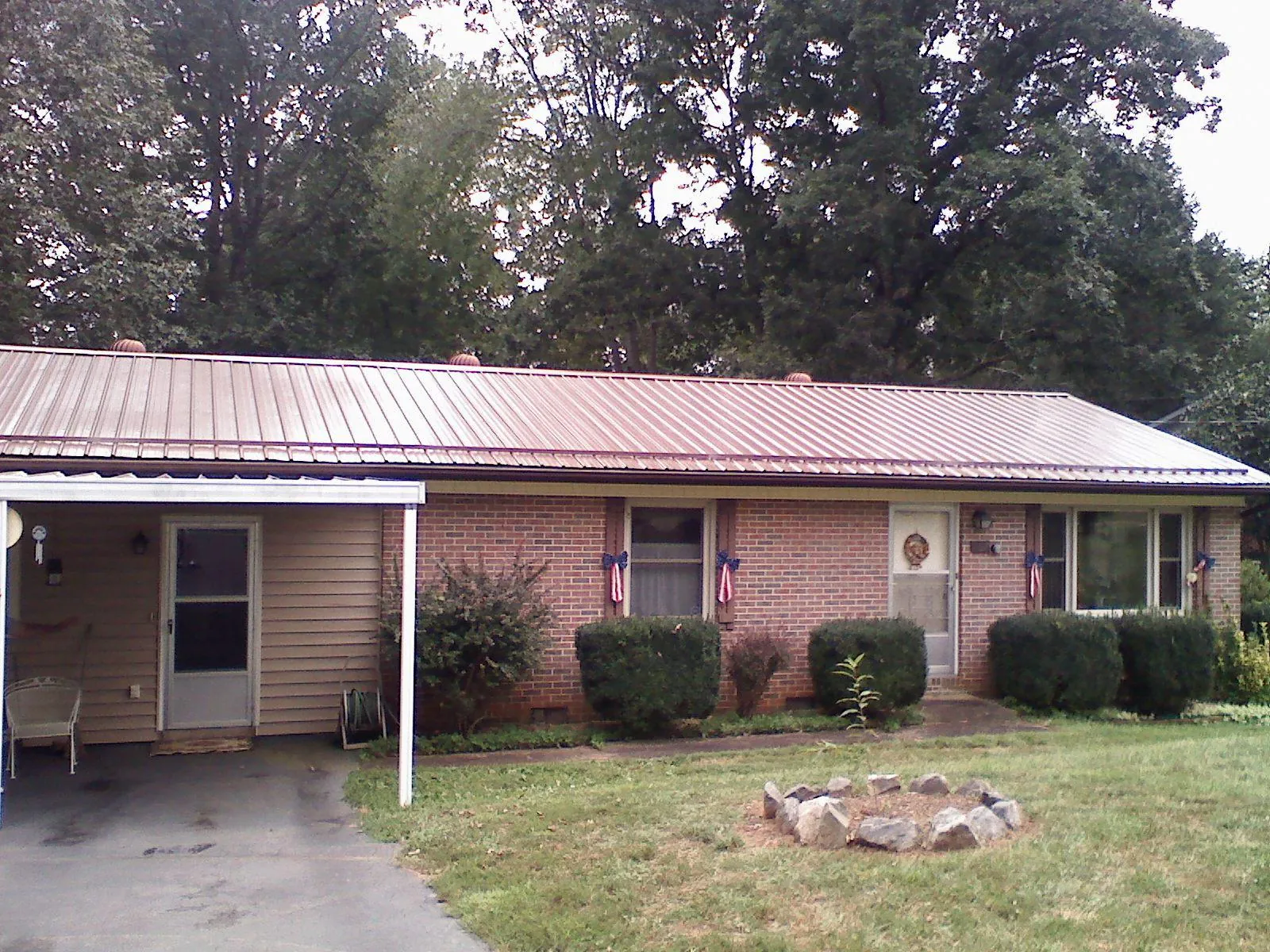 Bronze metal roof and carport on a brick ranch home — Roof Repair work by our crew in Woburn